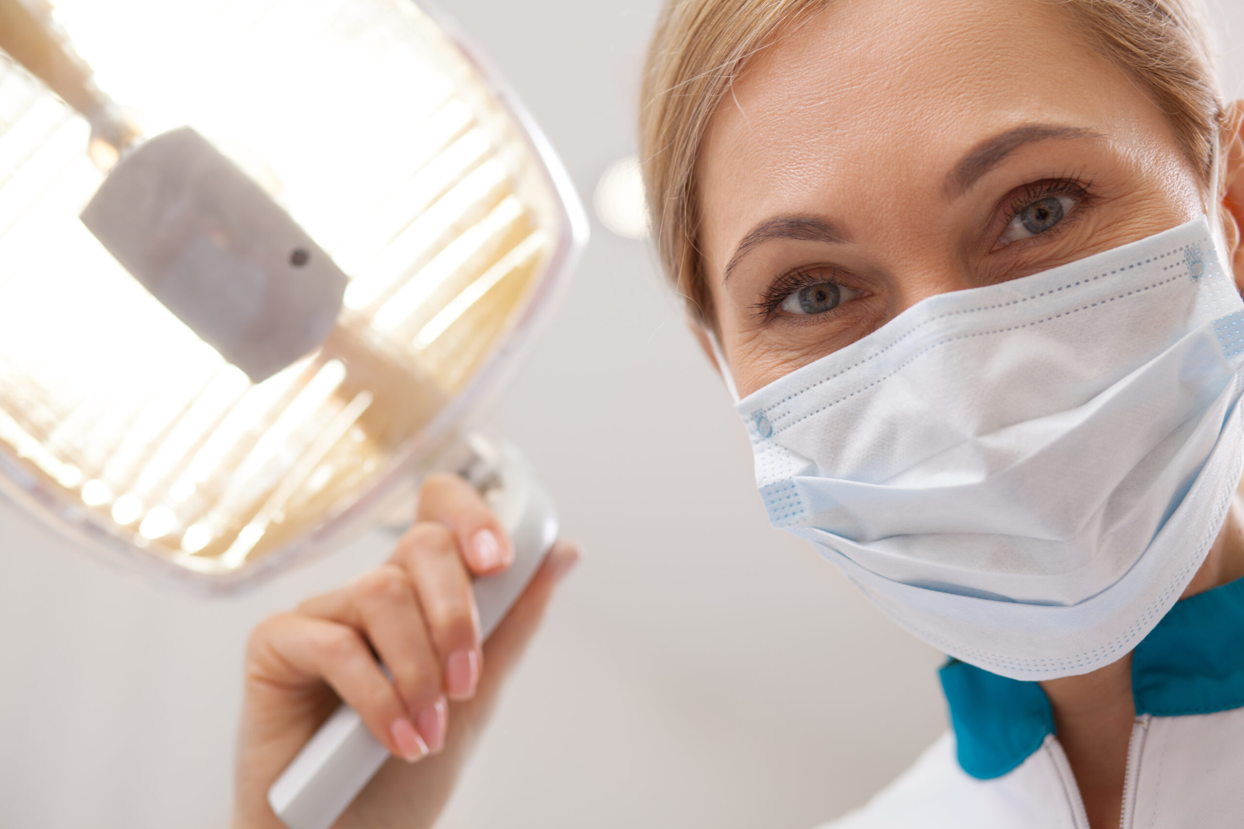 Close Up Of A Mature Female Dentist Smiling, Wearing Medical Mas